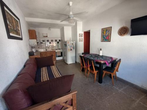 een woonkamer met een bank en een tafel bij Departamento zona muelle frente al mar in Villa Gesell
