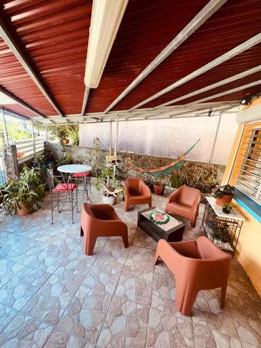 a patio with orange chairs and a table and a table at LE RÊVE EN COULEURS in Saint-Claude