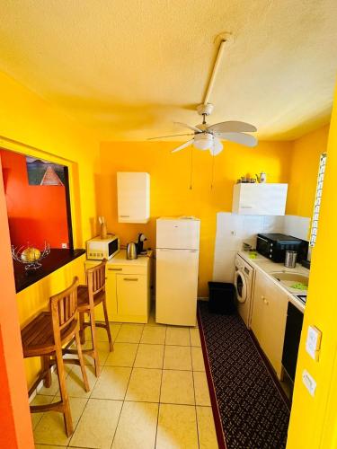 a kitchen with yellow walls and a ceiling at LE RÊVE EN COULEURS in Saint-Claude