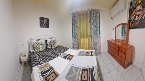 ein Schlafzimmer mit einem Bett und einer Kommode darin in der Unterkunft LE RÊVE EN COULEURS in Saint-Claude