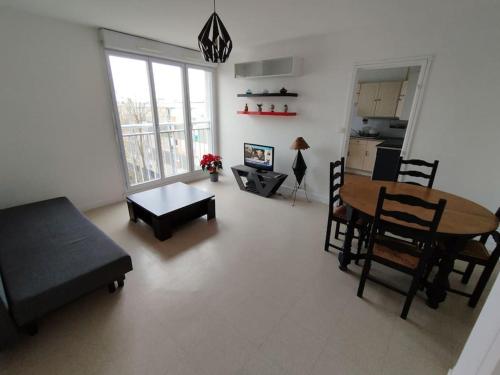 a living room with a table and a dining room at Appartement Courbaril à Nantes (6) in Nantes
