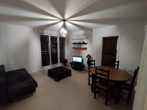 a living room with a dining room table and a couch at Appartement Courbaril à Nantes (6) in Nantes