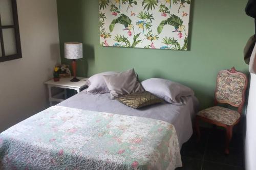 1 dormitorio con 1 cama y 1 silla en Casa Estrela do Mar, en Saquarema