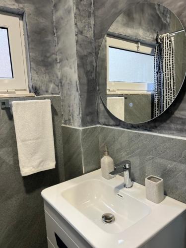 y baño con lavabo y espejo. en BOHO Cane Apartment, en Tirana