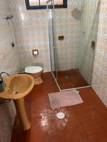 uma casa de banho com um chuveiro, um lavatório e um WC. em República Cruz Vermelha em Ouro Preto