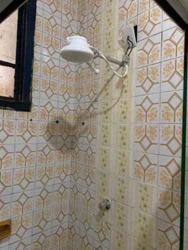 um chuveiro com luz numa parede de azulejos em República Cruz Vermelha em Ouro Preto