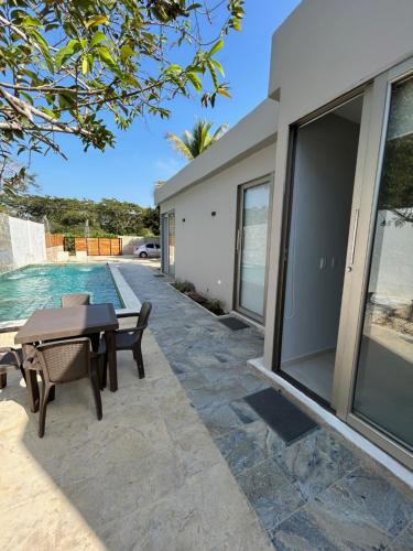 a patio with a table and chairs next to a house at DELAMAR Casa de playa in Coveñas