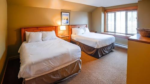 a hotel room with two beds and a window at Pinnacle Ridge Chalets by Fernie Lodging Co in Fernie