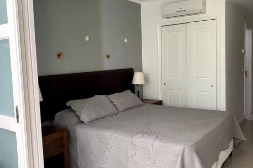 a bedroom with a bed with a white comforter at Depto PB con Jardín - Green Park in Punta del Este
