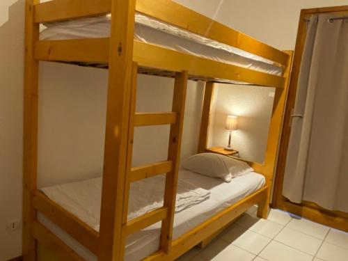 Ce lit se trouve dans un dortoir doté de 2 lits superposés et d'une lampe. dans l'établissement Appartement Valloire, 2 pièces, 4 personnes - FR-1-263-422, à Valloire