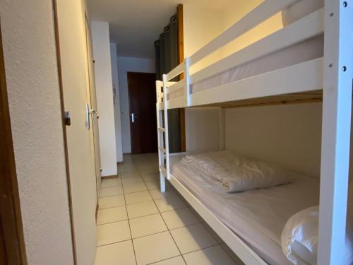 Cette chambre comprend 2 lits superposés et un couloir. dans l'établissement Appartement cosy Valloire 4 pers, proche télécabine - FR-1-263-421, à Valloire
