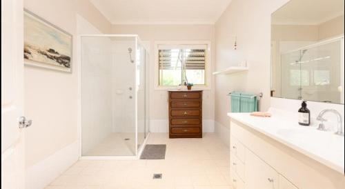 a white bathroom with a shower and a sink at wonderwander -the whole farm house in Ravensfield