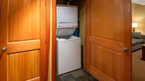 a kitchen with a washer and dryer next to a door at Pinnacle Ridge Chalets by Fernie Lodging Co in Fernie