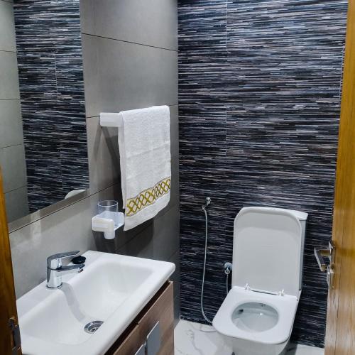 ein Badezimmer mit einem weißen WC und einem Waschbecken in der Unterkunft Super Apartement Totalement neuf a Marjane M2 in Tangier
