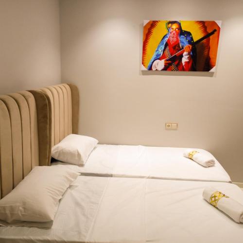 two beds in a room with a painting on the wall at Super Apartement Totalement neuf a Marjane M2 in Tangier