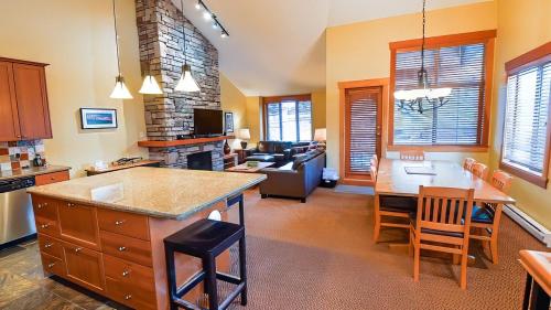 a kitchen and living room with a couch and a table at Pinnacle Ridge Chalets by Fernie Lodging Co in Fernie