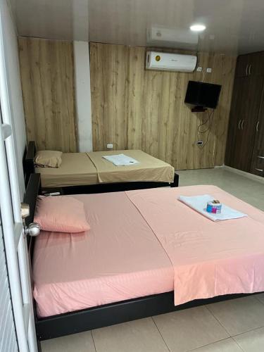 duas camas num quarto com lençóis cor-de-rosa em Posada Turística Marova em Inírida