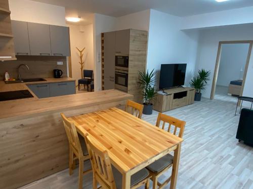 eine Küche und ein Wohnzimmer mit einem Holztisch und Stühlen in der Unterkunft Apartmány Hodonín in Hodonín