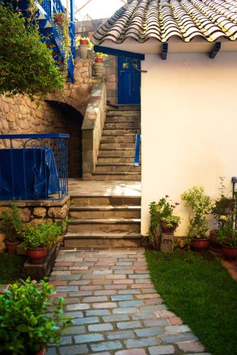 a stairway leading up to a house with a blue door at Rumi Wasi in Cusco