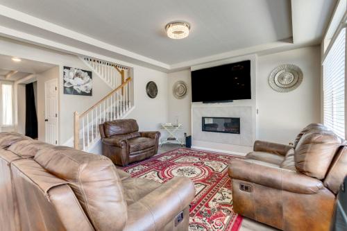 a living room with leather furniture and a flat screen tv at 17 Mi to Downtown Denver Modern Aurora Home! in Aurora