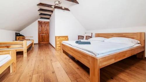 a large bedroom with two beds and wooden floors at Chalupa u Havranov in Bystrá