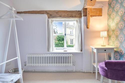 a room with a window and a purple chair at Stonemason's Cottage in South Cerney