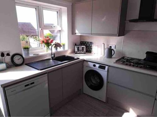 a kitchen with a sink and a washing machine at Binks Bungalow in New Hunstanton