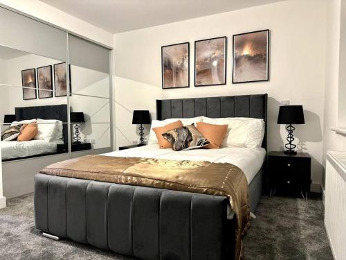 a bedroom with a large bed and some pictures on the wall at Brand new modern Cheltenham home 