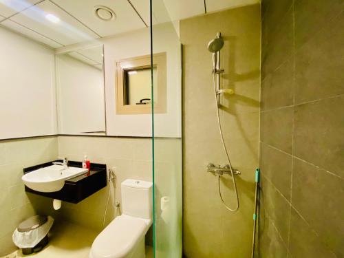 y baño con ducha, aseo y lavamanos. en Executive Master Bedroom In Shared Apartment en Dubái