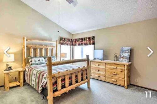 Schlafzimmer mit einem Holzbett und einem Schreibtisch in der Unterkunft Beautiful Lake Home w/ Paddle-boards & kayaks in Beaver Dam