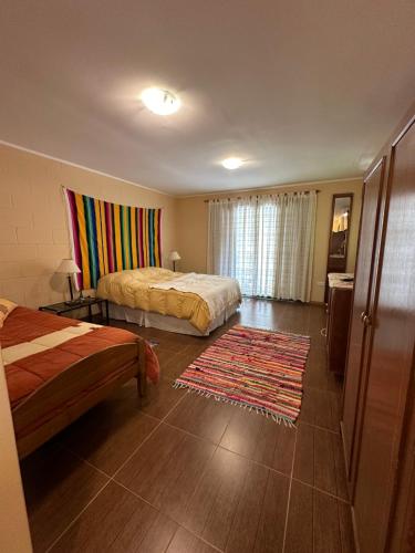 a hotel room with two beds and a rug at Altos del Cordón in Comodoro Rivadavia