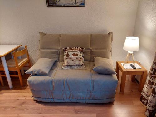 une ottomane bleue avec un oreiller en dessus dans l'établissement Studio rénové à Chamonix avec balcon, animaux acceptés, parking - FR-1-517-54, à Chamonix-Mont-Blanc