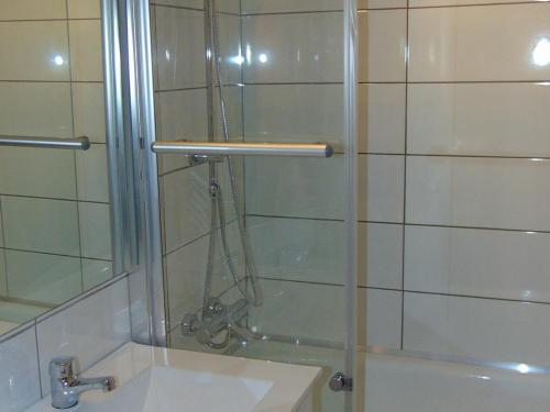 une douche avec une porte vitrée à côté d'un lavabo dans l'établissement Studio rénové à Chamonix avec balcon, animaux acceptés, parking - FR-1-517-54, à Chamonix-Mont-Blanc