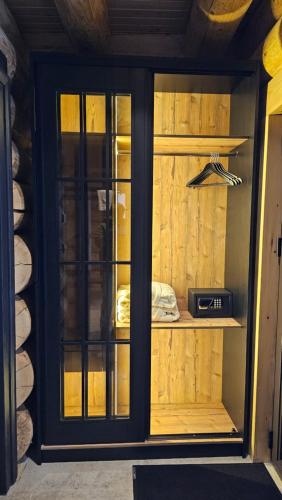 a wooden cabinet with glass doors in a room at Rtanj Kopaonik Eco Resort & Spa in Kopaonik