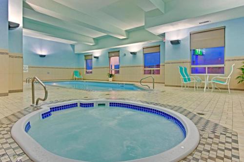 uma grande piscina num quarto de hotel com cadeiras em Holiday Inn Express Hotel & Suites-Edmonton South, an IHG Hotel em Edmonton