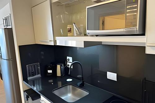 a kitchen with a sink and a microwave at Studio Moderno Amoblado en Puerto Madero in Buenos Aires