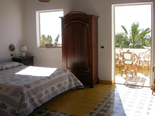 a bedroom with a large bed and a balcony at Hotel Macondo in Lampedusa