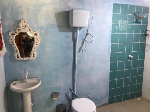 uma casa de banho com um lavatório, um WC e um espelho. em Camping Refúgio Shakti II em Florianópolis