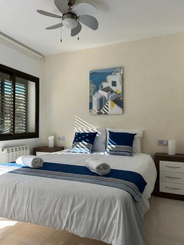 a bedroom with a large bed with blue and white pillows at Appartement Duplex Rosas avec terrasse magnifique jacuzzi vue mer in Roses