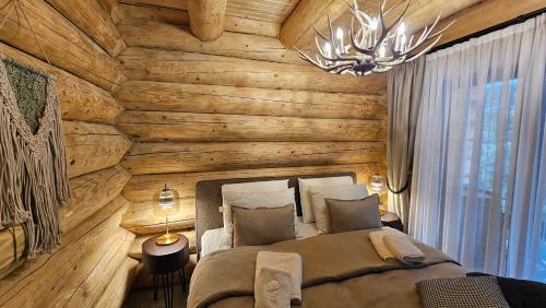 a bedroom with two beds and a wooden wall at Rtanj Kopaonik Eco Resort & Spa in Kopaonik