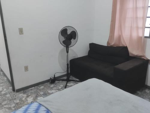 a living room with a fan and a couch at Fine Guest in Belo Horizonte