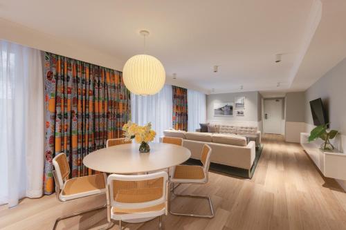 雪梨的住宿－齊本德爾阿迪娜公寓酒店，客厅配有桌椅和沙发