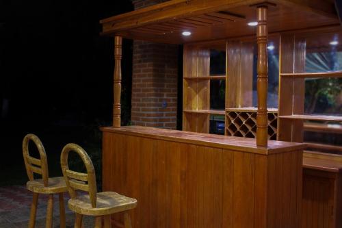een bar met 2 stoelen en een bar met wijnflessen bij Quinta Diana in Atlacholoaya