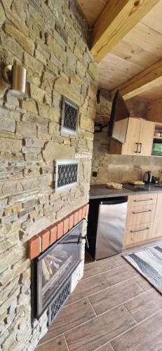 a kitchen with a stone wall and a stove at Babiogórskie Domki in Lipnica Wielka