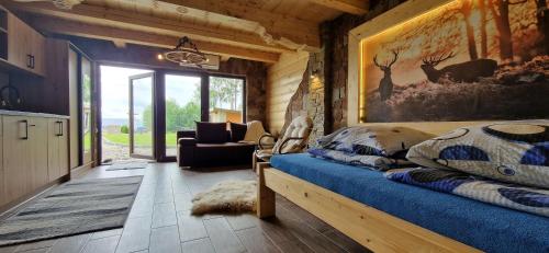 1 dormitorio con 1 cama en una cabaña de madera en Babiogórskie Domki, en Lipnica Wielka