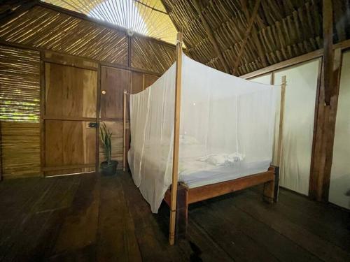 a bed with a net in a room at Casa Moringa in Palomino