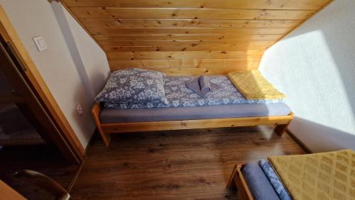 a small bed in the corner of a room at Babiogórskie Domki in Lipnica Wielka