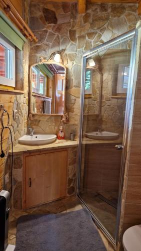 kamienna łazienka z 2 umywalkami i prysznicem w obiekcie Babiogórskie Domki w mieście Lipnica Wielka