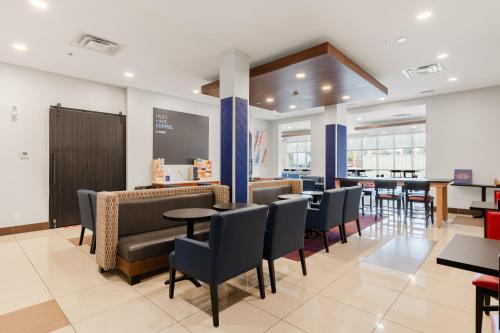 a restaurant with tables and chairs and a bar at Holiday Inn Express Hotel & Suites-Edmonton South by IHG in Edmonton
