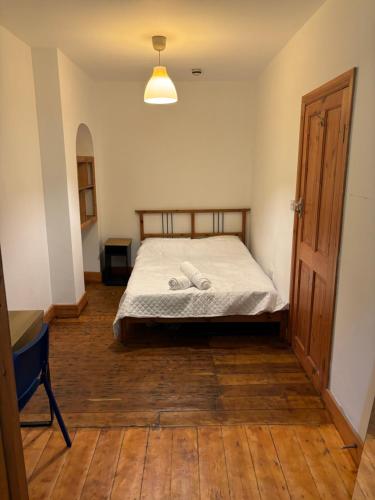 um quarto com uma cama e piso em madeira em Room137 Stay in Stoke Newington em Londres